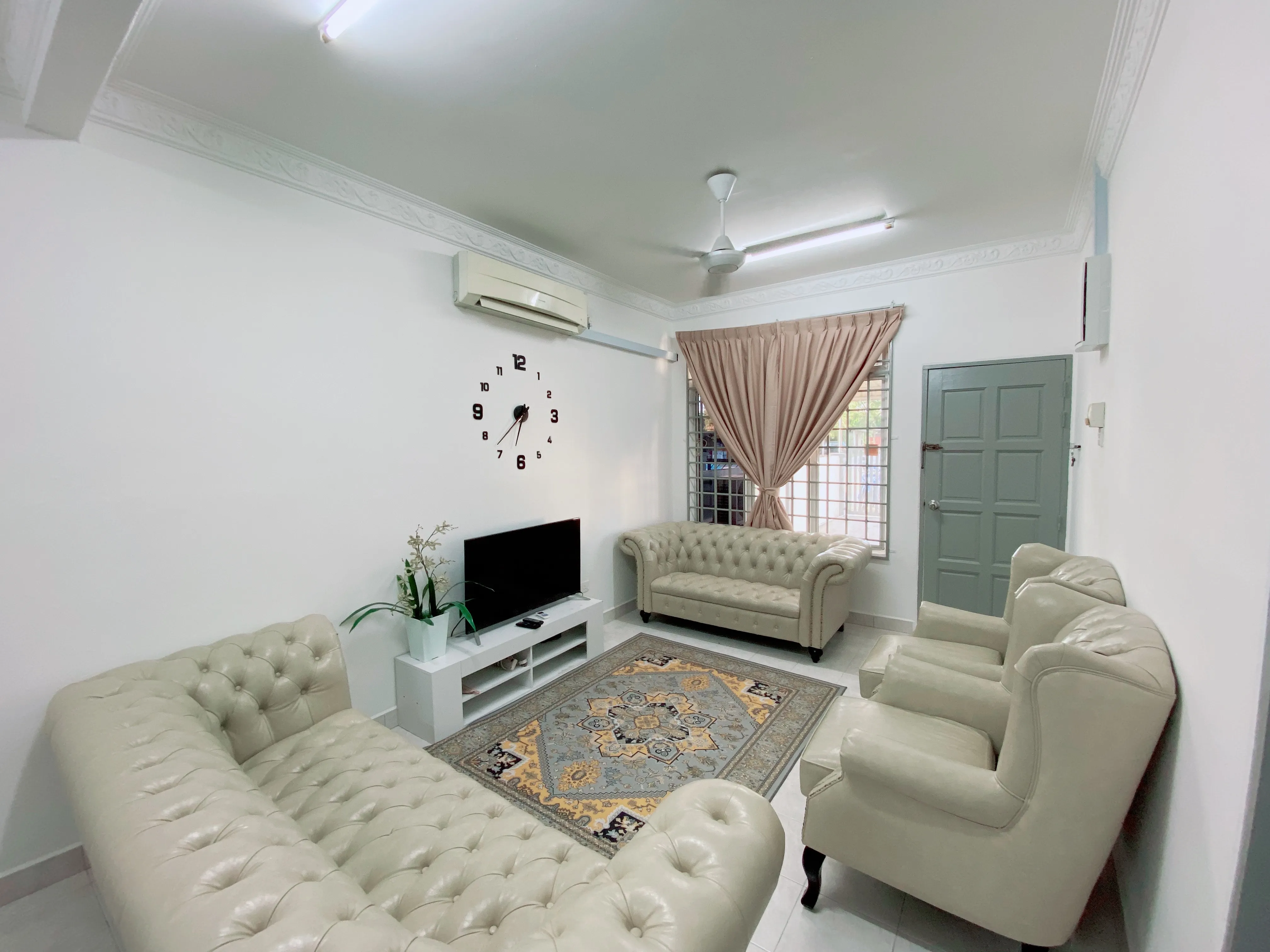 Ruang tamu homestay Kuala Terengganu dengan sofa dan televisyen